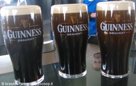 Three pints of Guinness Draught with foam on a bar counter