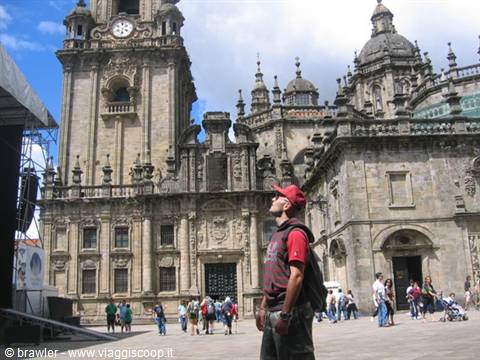Backpacker looking up at the baroque facade of Santiago de Compostela cathedral