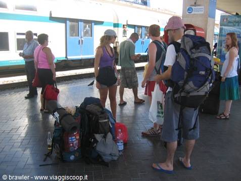 Backpackers with bags on the railway platform next to the train