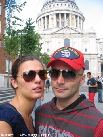 Couple in sunglasses and red cap in front of St Paul's Cathedral, London