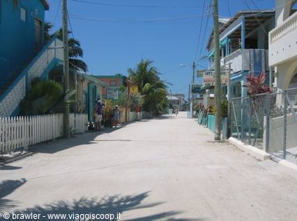 Sandy street lined with colorful wooden houses in Caye Caulker