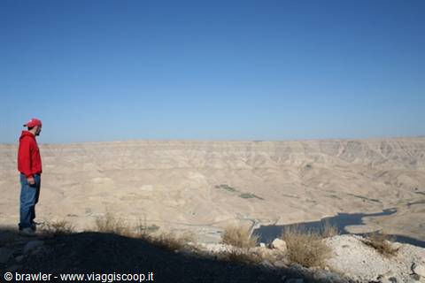 Man in red jacket overlooking Wadi Mujib canyon and the lake