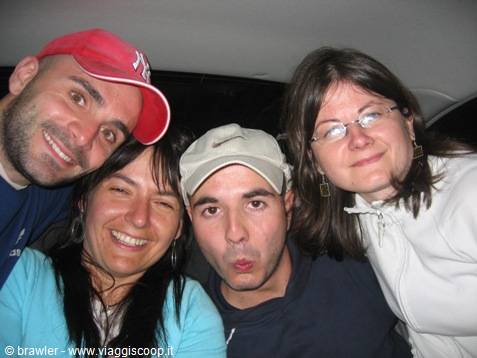 Four friends take a selfie inside a car, laughing and making funny faces