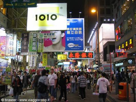Crowd under neon signs at night in Mong Kok, busy shops and billboards
