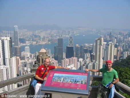 Two tourists beside an information board at Victoria Peak, Hong Kong skyscrapers