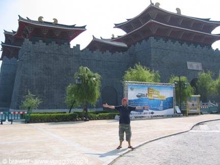 Tourist with open arms in front of Xi'an city gate, grey stone walls