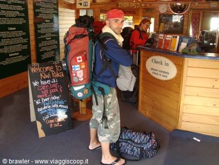 Backpacker with red bandana and large pack at Kiwi Paka hostel check-in