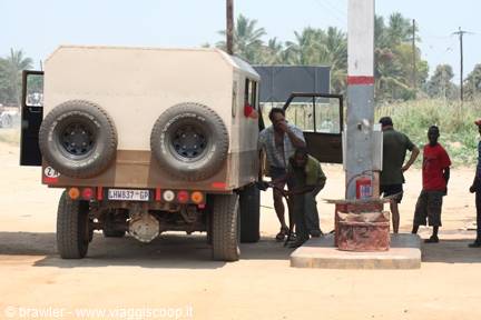 Safari truck with twin spare tires refueling at a rural petrol station