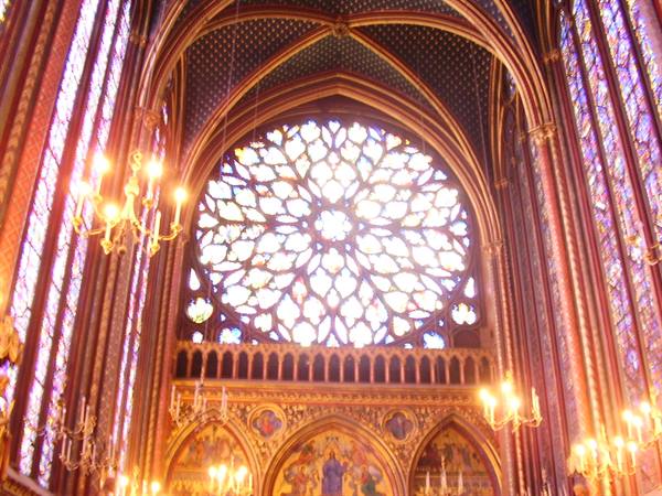 Glowing rose window in Sainte-Chapelle, Paris, stained glass lit by golden chandeliers
