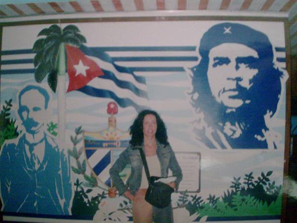 Woman with black bag in front of mural with Che Guevara, José Martí and Cuban flag