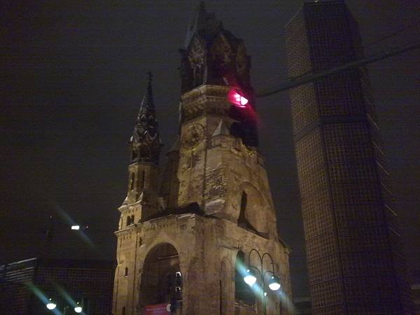 Kaiser Wilhelm Memorial Church at night, red light on stone ruins
