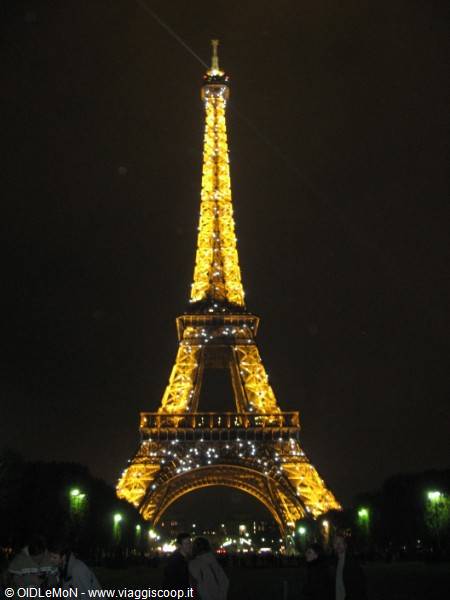 Eiffel Tower lit up at night, golden sparkling lights on the iron structure