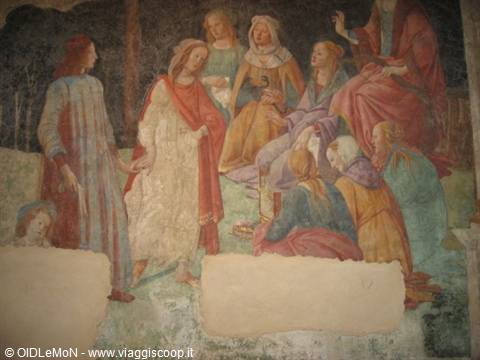 Fresco of women in colorful robes, with missing plaster patches