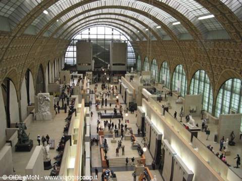 Great hall of the Musée d'Orsay with iron vaults, light and visitors among sculptures