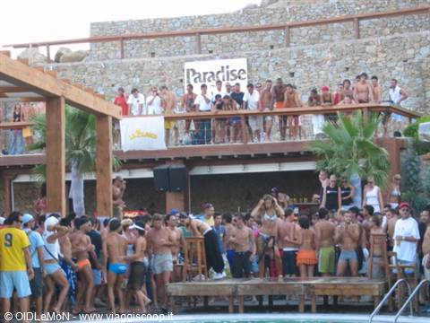 Crowd in swimwear partying at Paradise bar, wooden stage dancing