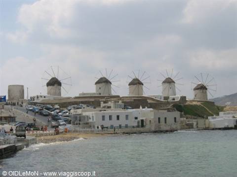 The famous white windmills of Mykonos above the harbour houses