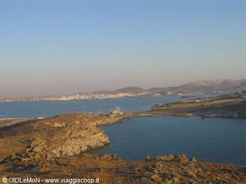 Bay with harbor among dry rocks, white town across the water
