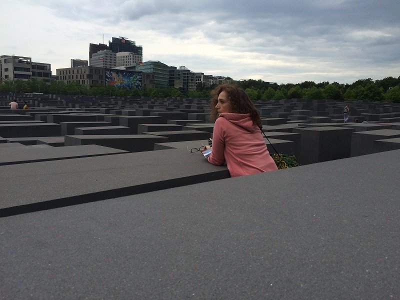Donna appoggiata alle stelle di cemento del Memoriale dell'Olocausto a Berlino