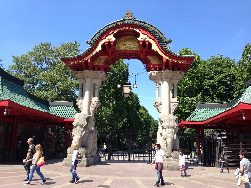 Porta degli Elefanti dello Zoo di Berlino, archi rossi e tetti verdi, visitatori camminano