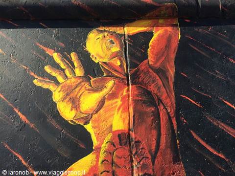 Mural painted in red and yellow on the Berlin Wall at East Side Gallery