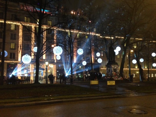 Sfere luminose natalizie tra gli alberi davanti all'Hotel InterContinental, fasci di luce notturni