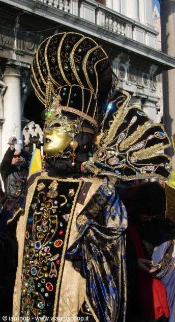 Costumed masker in brocade and golden headdress at St Mark's Square, Venice