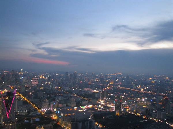 Bangkok city lights at dusk, blurry skyscrapers seen from above