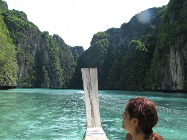 Woman on a longtail boat among limestone cliffs and turquoise Phi Phi waters