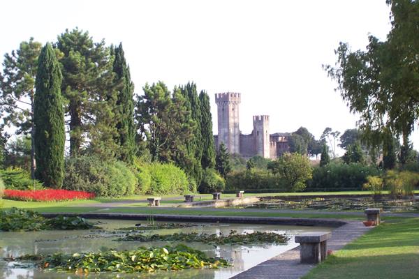 Lily pond with stone benches in front of a crenellated castle tower