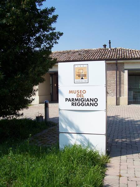 White sign of the Parmigiano Reggiano museum in front of the farmhouse