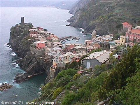 Vernazza: colorful houses on the rock, medieval tower and harbor among the waves