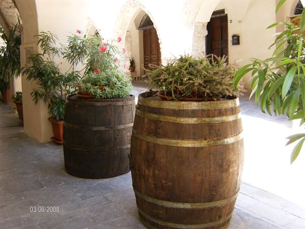 Wooden barrels with flowers under stone arches