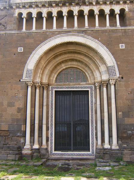 Romanesque portal with blind arches, stone columns and geometric decorations