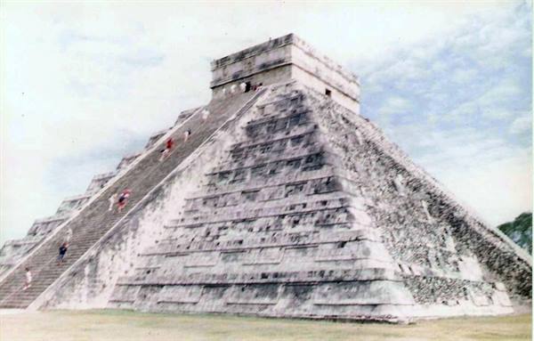 Tourists climbing the stone staircase of El Castillo pyramid at Chichén Itzá