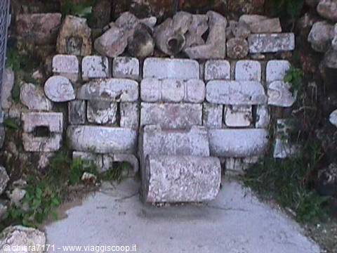 Ancient carved stone blocks, possibly Mayan ruins, set into a wall