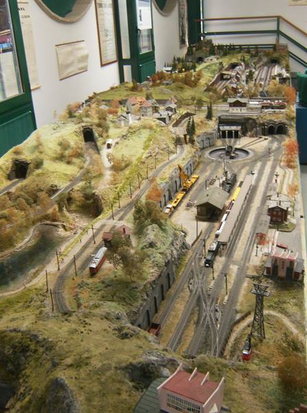Model railway layout with mountains, tunnels and locomotive depot in a museum