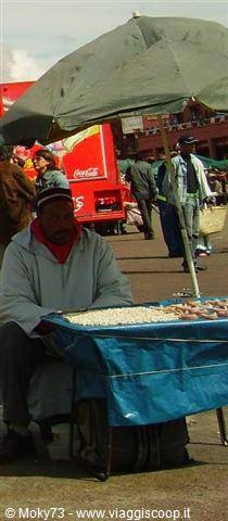 Street vendor under a green umbrella in Marrakech's Jemaa el-Fna square