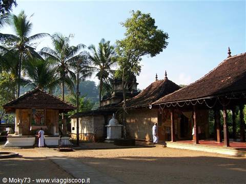 Gadaladeniya Buddhist temple, tiled roofs, palm trees, worshippers in white
