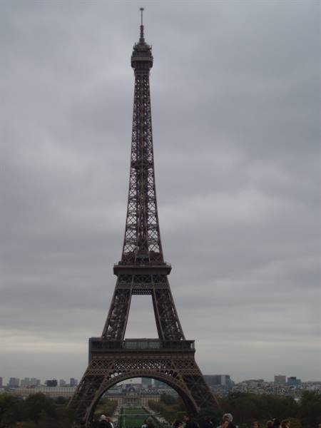The wrought-iron Eiffel Tower under a grey sky, seen from Trocadéro