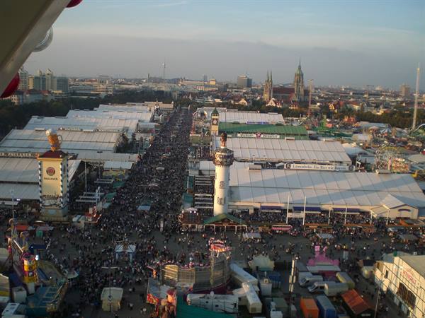 Oktoberfest in Munich: crowds among white beer tents and gin tower