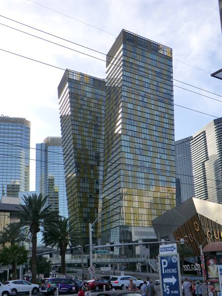 Gold glass skyscrapers along the boulevard with palms and traffic in Las Vegas