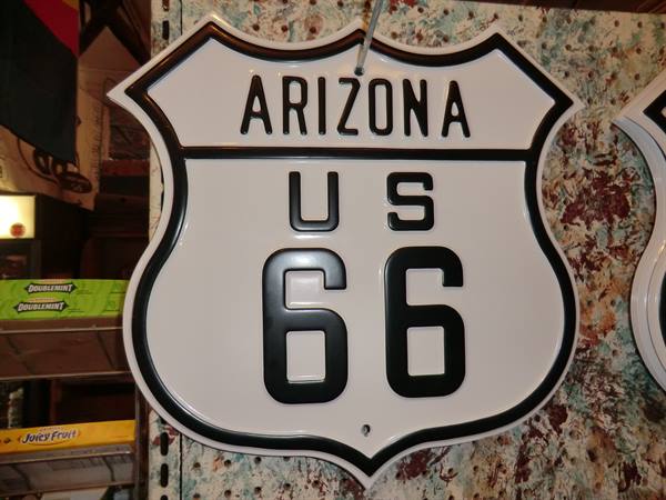 White metal Arizona Route 66 shield sign hanging in a souvenir shop