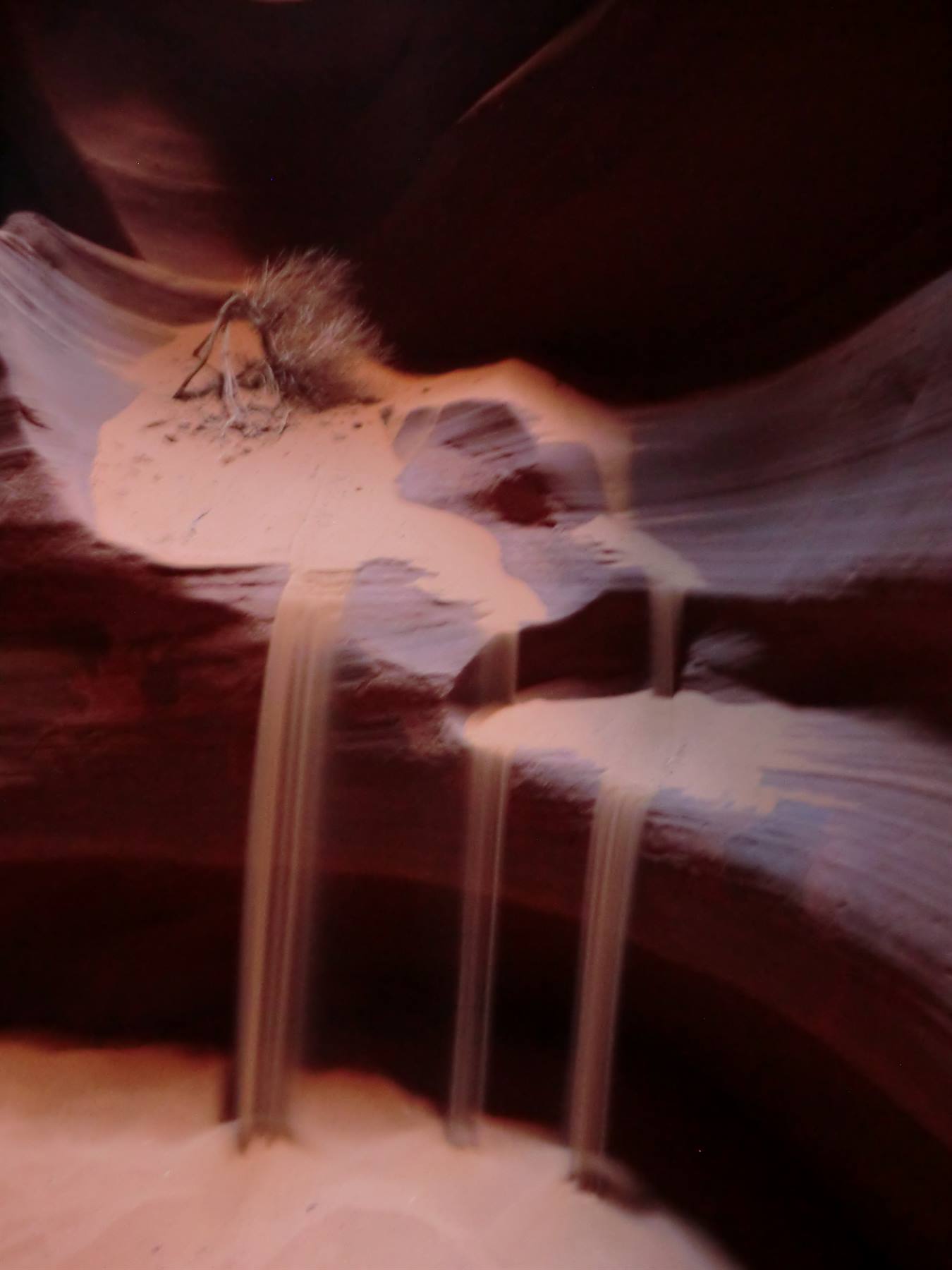 Sabbia che cola come cascate nella roccia ondulata di Antelope Canyon