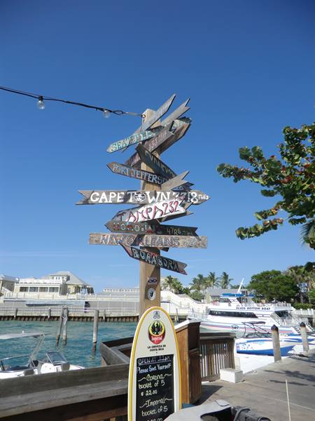 Wooden signpost pointing to Cape Town and New Orleans at Key West harbor