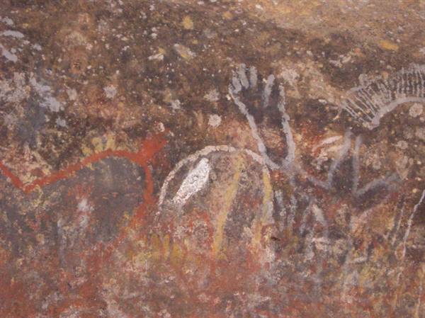 Ancient ochre and white rock paintings, printed hands on stone