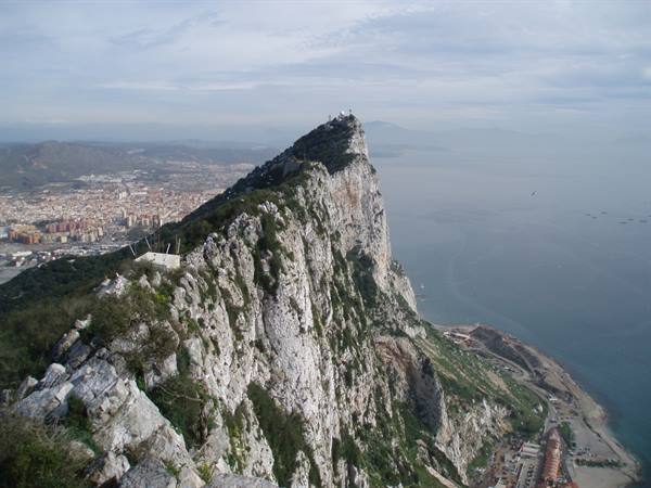 The limestone Rock of Gibraltar plunges into the sea, town below