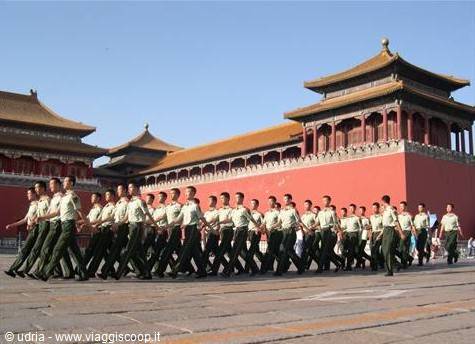 Soldiers marching in the Forbidden City, Beijing, red walls and golden roofs