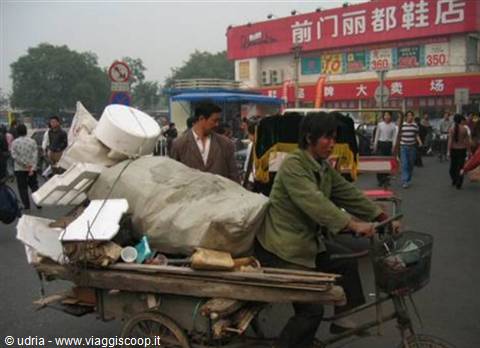 Man loading scrap onto cargo tricycle, Qianmen street, Beijing