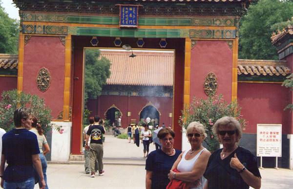 Tourists at the red gateway of Yonghe Temple, incense smoke rising inside