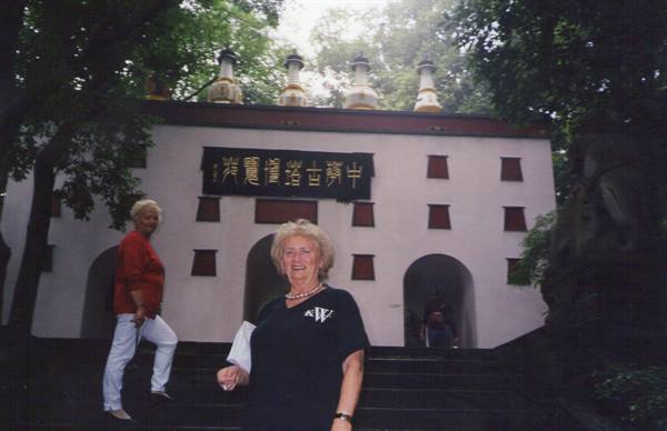 Two tourists on the steps of the white Lingyin temple with Chinese inscription